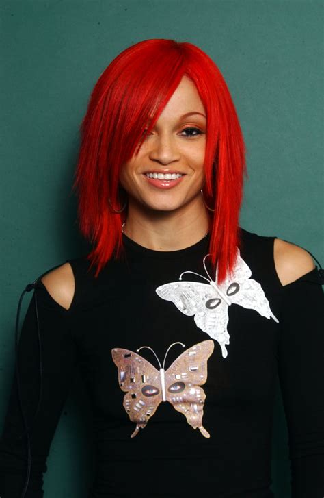 A Woman With Red Hair Wearing A Black Shirt And Butterfly Applique On