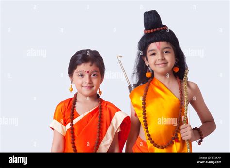 Portrait Of Smiling Children Dressed As Ram And Sita Against White