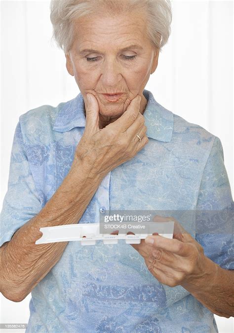 Senior Woman Looking Baffled At Pillbox High Res Stock Photo Getty Images