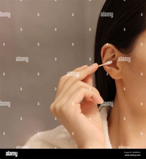 Woman Cleaning Her Ear With A Cotton Swab After Taking A Shower