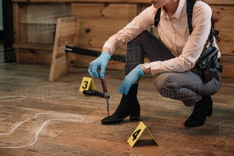 Cropped View Of Female Detective Collecting Evidence At Crime Scene