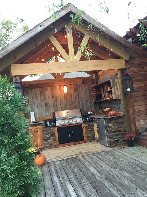 An Outdoor Kitchen Is Built Into The Side Of A Wooden Building With A