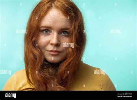 portrait of beautiful redhead girl with gorgeous curly hair crossed smiling looking at camera