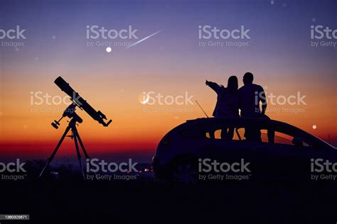 Couple Stargazing Together With A Astronomical Telescope Stock Photo