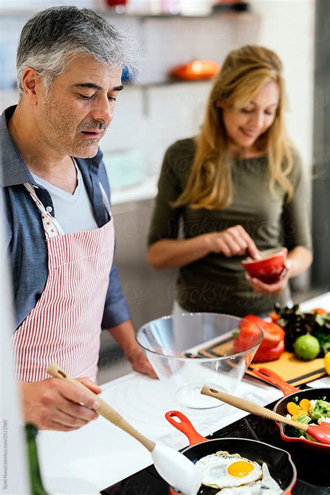 Married Couple Cooking Together At Home By Stocksy Contributor Santi