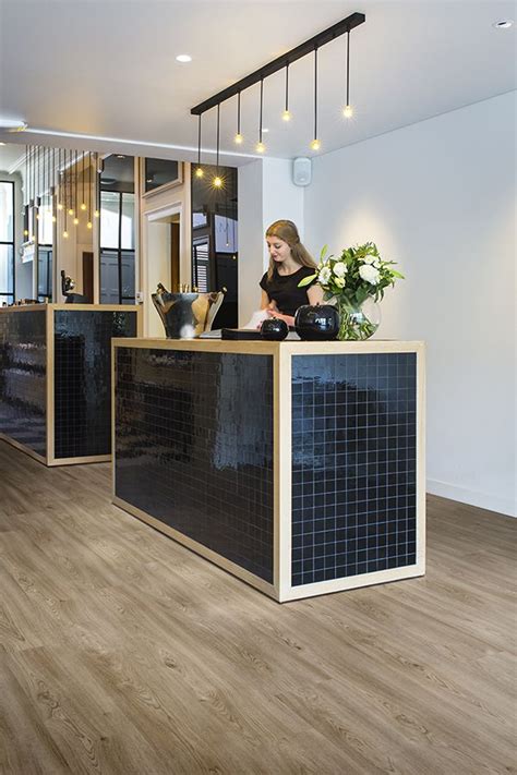 A reception desk is often the first thing clients see upon entering a corporate space. Black & wood reception desk with ambient lighting - PURE ...