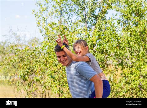 Defocused Brother Giving Sister Ride On Back Portrait Of Happy Girl