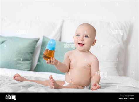 Cute Little Baby Drinking Juice From Bottle At Home Stock Photo Alamy