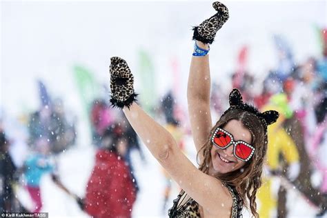 A Woman Wearing Cat Ears And Holding Her Arms Up In The Air While Snow