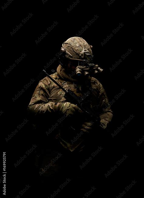Soldier In Military Uniform With Assault Rifle Standing On Background