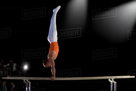 Male Gymnast Performing Handstand On Parallel Bars Side