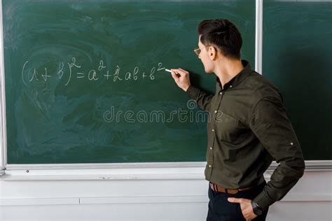 Serious Male Teacher In Formal Wear Looking At Camera And Standing Near
