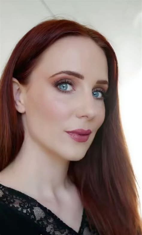 a woman with long red hair and blue eyes