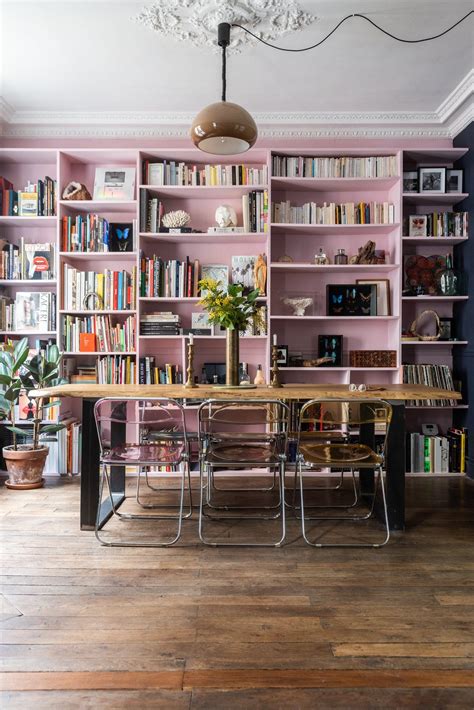 A Dining Room Table And Chairs In Front Of Bookshelves With Shelves