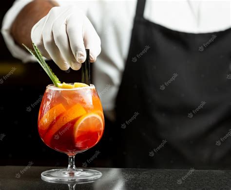 Free Photo Waiter Puts Plastic Straws In Sangria Cocktail In Glass