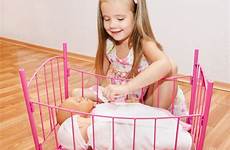girl little playing baby dolls her cute newborn smiling stock
