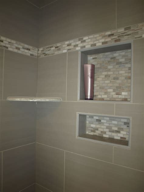 A Bathroom With White Tile Walls And Gray Tiles On The Shower Wall