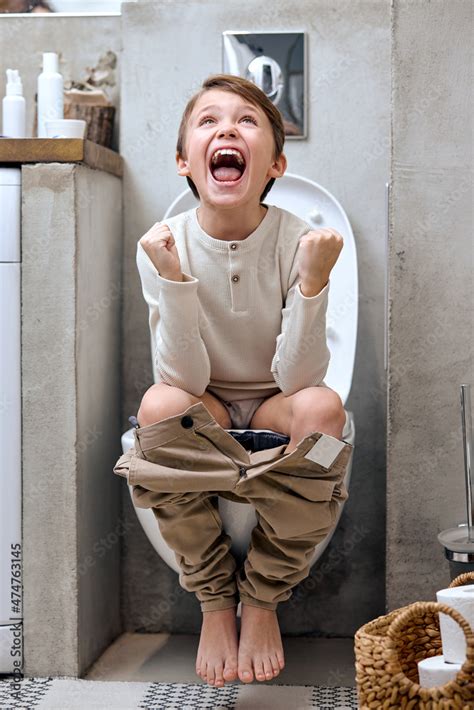Excited Young Teen Boy Sitting On Toilet With Pants Down Rejoicing