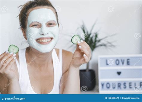 Young Pretty Blonde Woman With Facial Mask Posing With Cucumber Stock