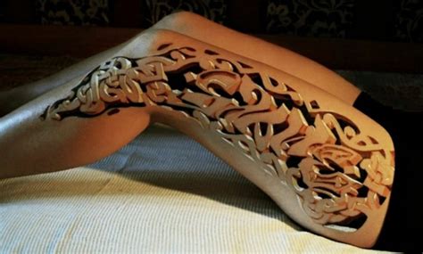 Eine hand und beine einer jungen frau, ein bein mit einem kleinen schwarzen tattoo mit weißen blumen und. 3D Tattoo: realistische Tattooideen für Damen und Herren