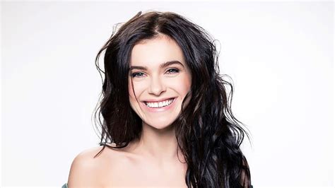 brunette elena temnikova singer with black hair and cute smile in white background elena