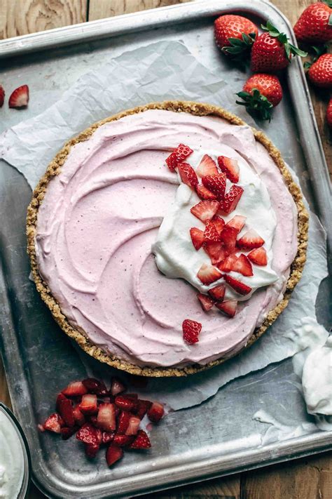 A Pie With Strawberries And Whipped Cream On Top Is Sitting On A Baking