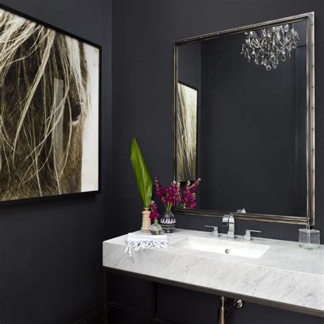 A Bathroom With Black Walls And White Marble Counter Top Chandelier