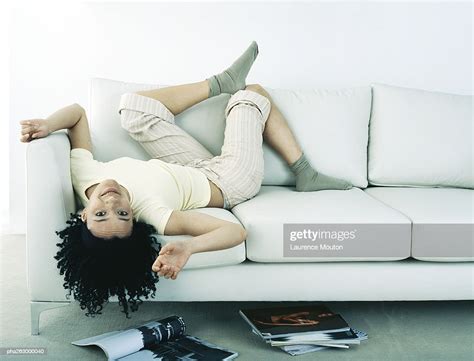 Woman Lying On Back On Sofa Head Hanging Upside Down Off Sofa Magazines