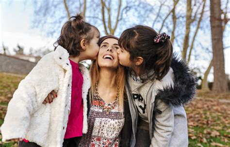 Happy Mother Kissed By Her Little Daughters Stock Photo
