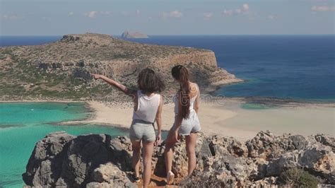 Two Beautiful Girls Standing On Edge Of Cliff Female Friends Admire