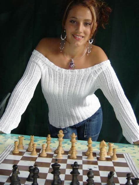 A Woman Is Posing Next To A Chess Board
