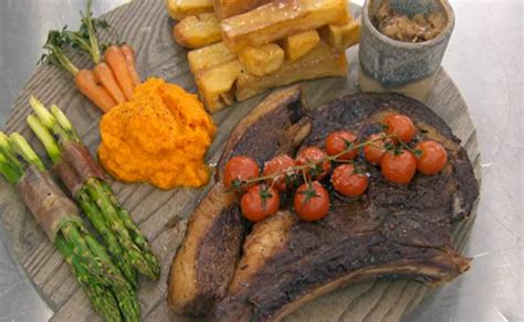 Tomahawk rib beef steak on grill. Aj's rib eye steak with asparagus and brandy sauce on ...