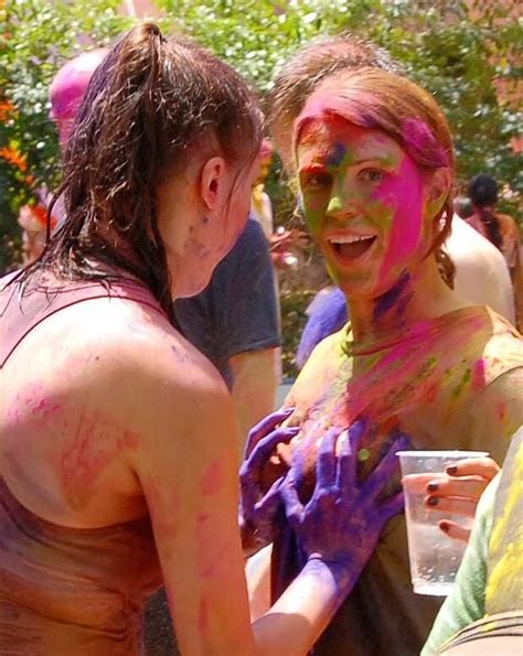 Two Women Covered In Colored Powder Having Fun At A Holi Day Event With
