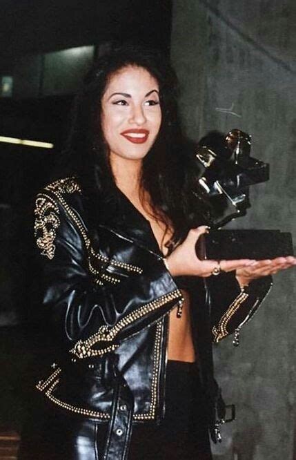 A Woman In Leather Jacket Holding A Black Object