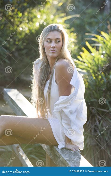 australian with long blond hair sitting on bridge looking away stock image image of woman
