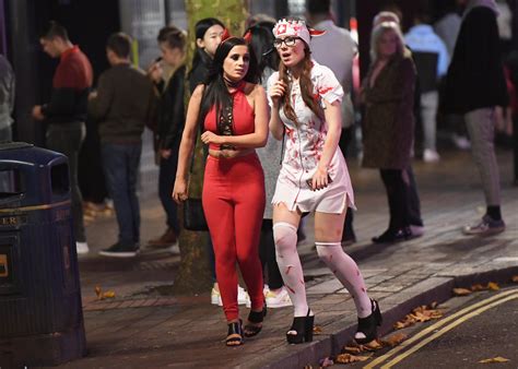 Walking Down The Street On Halloween Night Song - Halloween party-goers in serial killer and sexy nurse fancy dress hit