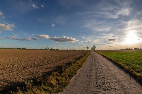 A Dirt Road Leading Between Cultivated Fields A Country Road Le Stock