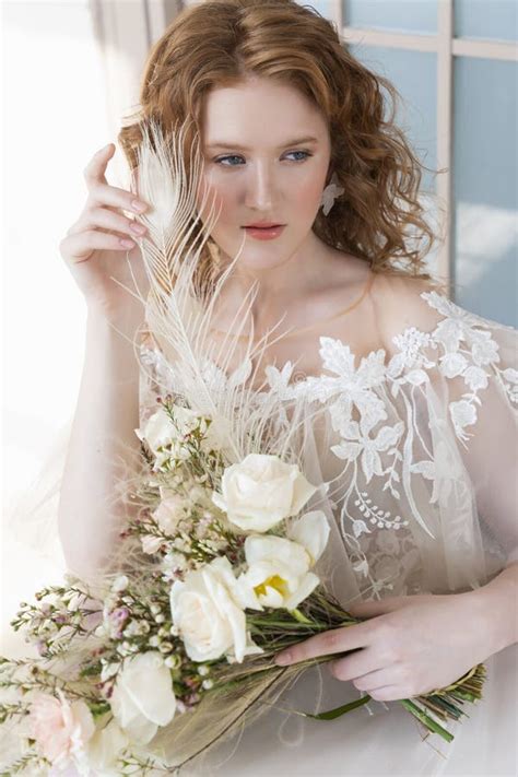 Beautiful Natural Redhead Girl Bride With Nude Makeup Wearing A White Dress Holds A Wedding