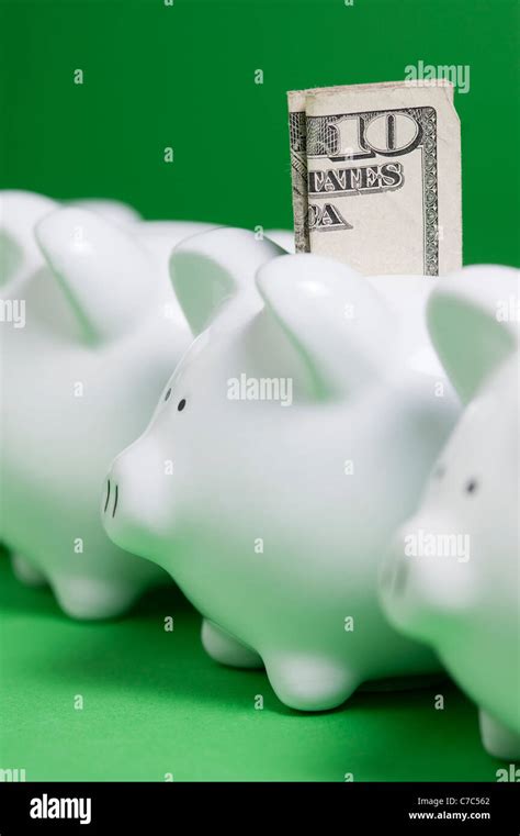 Rows Of Piggy Banks With Money Coming Out Of Coin Slots Stock Photo Alamy