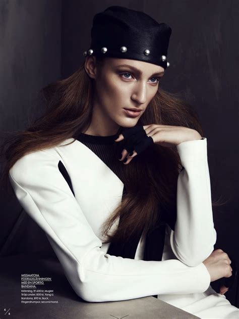 A Woman With Long Hair Wearing A Black Hat And White Dress Sitting At A