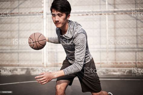 Young Asian Basketball Player Practicing Dribbling Skills On Outdoor