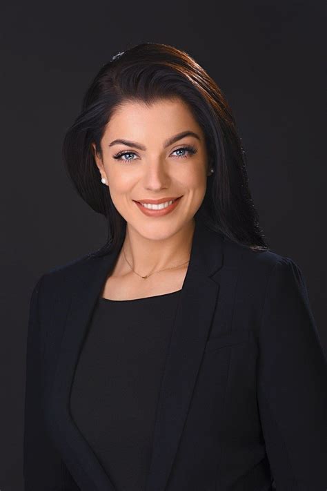 a woman in a black suit smiling at the camera
