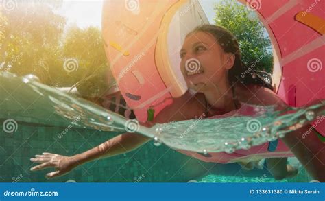 Young Hipster Millennial Girl In Sprinkled Donut Float At Pool Smiling Look At Camera Young