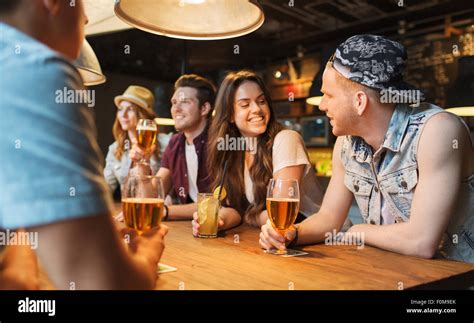 Happy Friends With Drinks Talking At Bar Or Pub Stock Photo Alamy