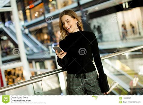 Lovely Young Woman Looking On Mobile Phone In Shopping Center Stock