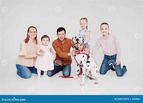 Familia Jugando Con Un Perro Dálmata De Fondo Blanco Foto De Archivo
