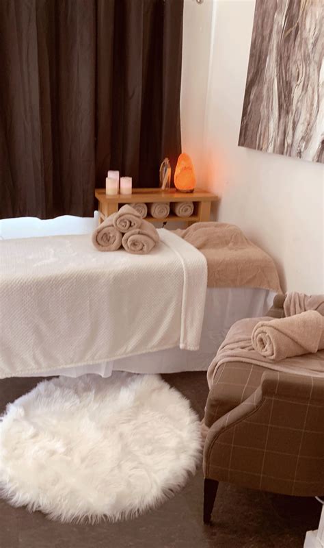 a white bed sitting next to a chair in a room with towels on top of it