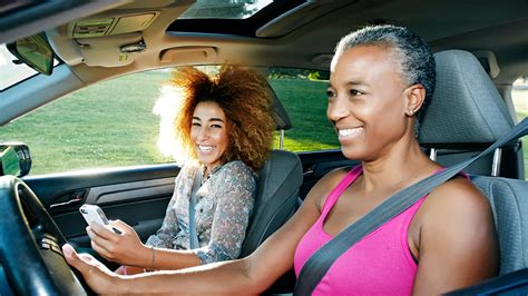 Two Women In A Car Driving And Smiling