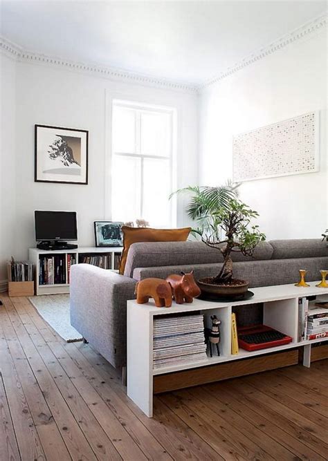 One typical way to decorate a sofa table is with a pair of lamps. 20 Great Ways to Make Use Of The Space Behind Couch For Extra Storage And Visual Depth - Hative