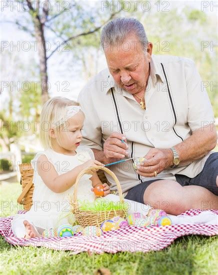 Loving Grandfather And Granddaughter Coloring Easter Eggs Together On Picnic Bla Imagebroker